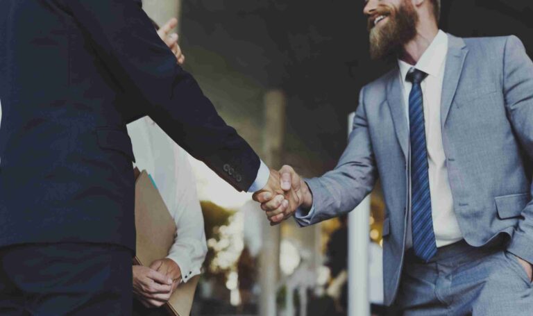 Men shaking hands discuss channel marketing partnership.